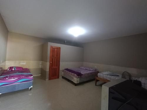 1 dormitorio con 2 camas y una luz en el techo en Hotel Sleep Inn Brumas en Jinotega