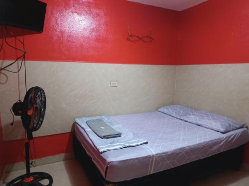 a small bedroom with a bed and a fan at Hotel Sleep Inn Brumas in Jinotega
