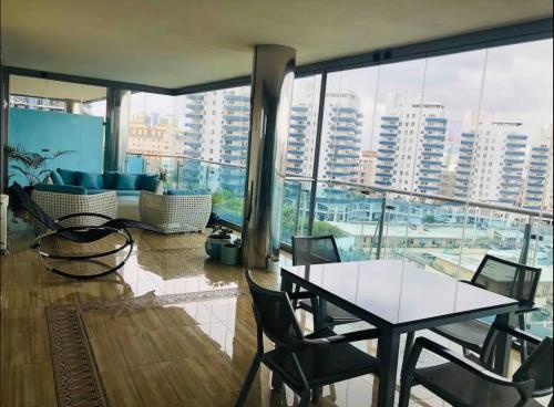 a room with a table and chairs and a large window at APARTMENT IN OCEAN VILLAGE, SLEEPS UP TO 6 in Gibraltar