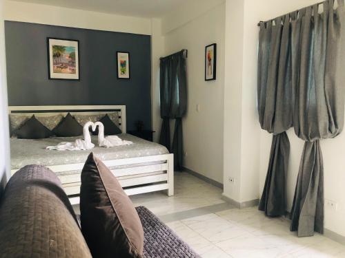 a bedroom with a bed and a couch at Batey Hotel Boutique in Boca Chica