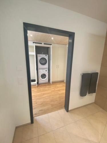 an open doorway to a room with a washing machine at WAZ Wohnen auf Zeit - Flums in Flums
