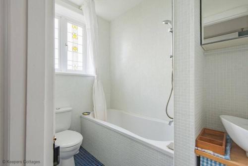 y baño con bañera, aseo y lavamanos. en Bayside House en Westgate on Sea