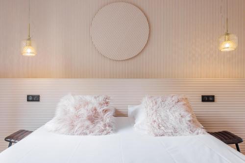 a bedroom with two beds with pillows and a mirror at CMG Résidence Canal Saint-Martin Vellefaux in Paris