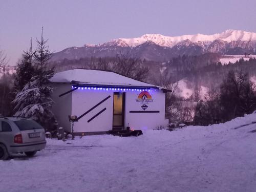 a small building with lights on it in the snow at Touch the Sky in Moieciu de Jos