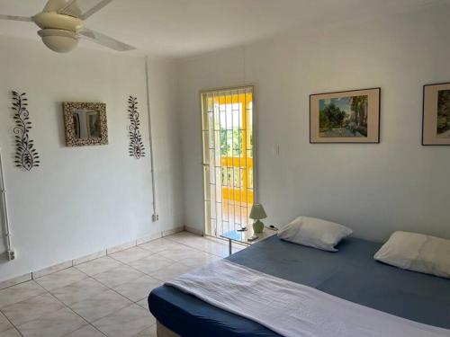 a bedroom with a blue bed and a window at Traumhaus am Hang mit privatem Pool in Barber