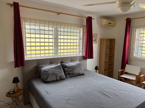 a bedroom with a large bed with red curtains at Traumhaus am Hang mit privatem Pool in Barber