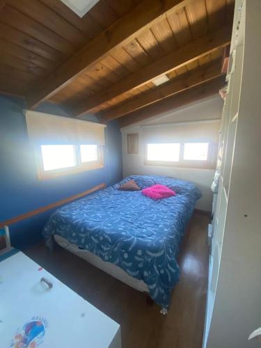 een slaapkamer met een bed in een kleine kamer bij Ohana in Ushuaia