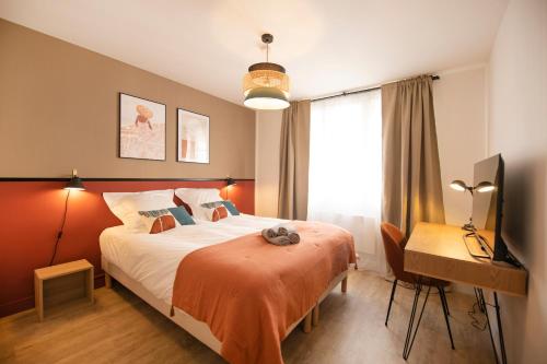 une chambre avec un lit, un bureau et une télévision dans l'établissement Chambord - Hypercentre, à Orléans