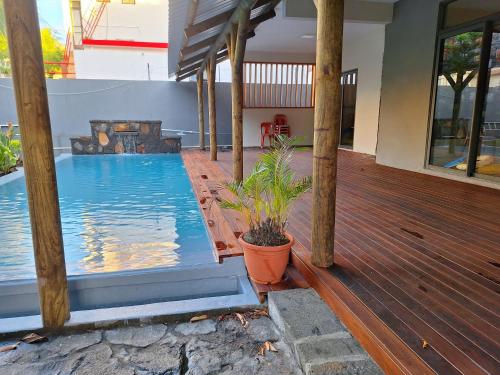 une maison avec une piscine sur une terrasse en bois dans l'établissement 3 bedrooms -swimming pool- fully equipped kitchen, à Roches Brunes