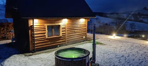 a dog house in the snow at night at Kryjówka Yetiego Domek w zaciszu Bieszczad z jacuzzi in Hoczew