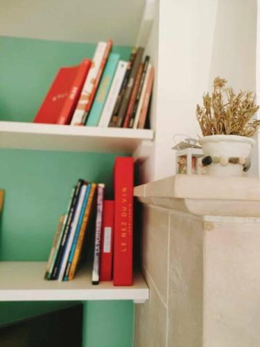 a book shelf filled with books and a vase at Emplacement idéal dans le Var ! in Cuers