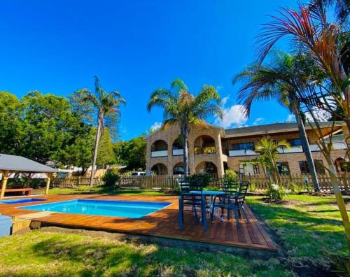 a house with a table and chairs next to a pool at Lagoon Breeze Guest House in Knysna