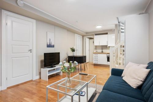 a living room with a blue couch and a glass table at New! Modern City Apt: Central w/ Private Entrence in Bergen