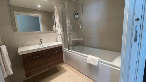 bagno con lavandino e vasca di Mercury Tower Suites a Paceville