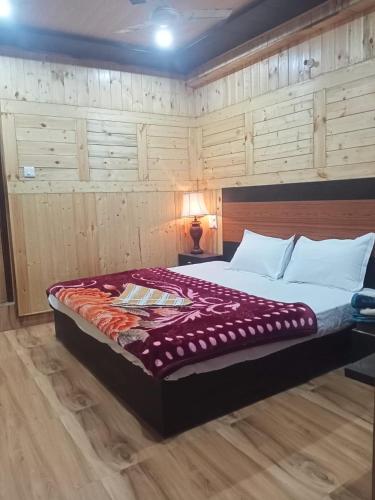 een slaapkamer met een groot bed en een rode deken bij Aapka Ghar Guest House in Bhīm Tāl