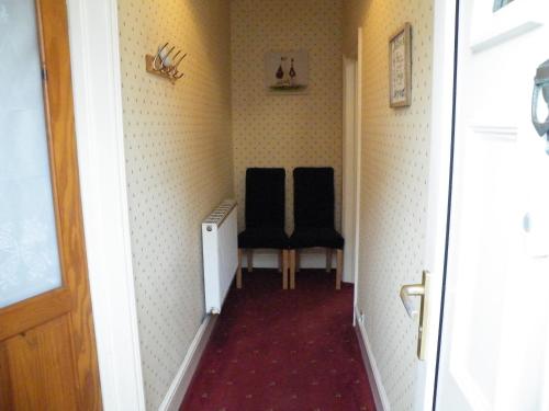 two black chairs sitting in a hallway at Family Home Near City Centre - New KING bed! in Carlisle