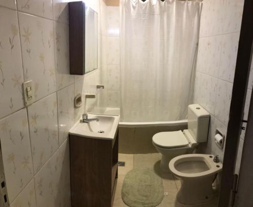 a bathroom with a sink and a toilet and a tub at Acogedora Casa Céntrica in Ciudad del Este
