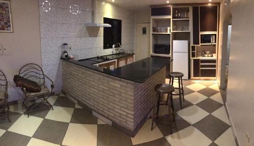uma cozinha com um balcão e dois bancos em Acogedora Casa Céntrica em Ciudad del Este