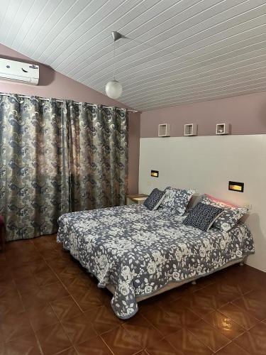 a bedroom with a bed and curtains in a room at Acogedora Casa Céntrica in Ciudad del Este