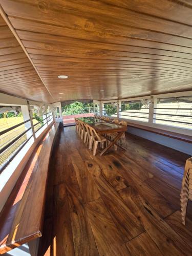 a dining room with a wooden table and benches at Beach Paradise Day Cruise Houseboat in Alleppey