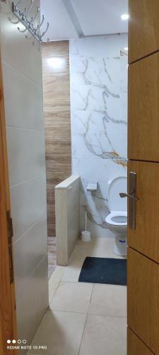 Łazienka z toaletą i marmurową ścianą w obiekcie Jenan elkhyer Ben guerir w mieście Benguerir