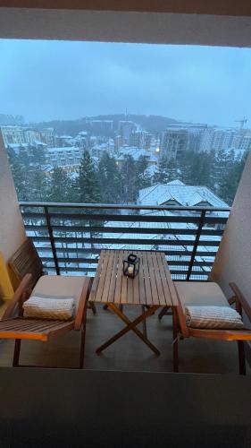 a table and chairs on a balcony with a view at Lux apartment Sky Central Residence Zlatibor in Zlatibor