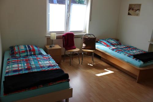 Zimmer mit 2 Betten und 2 Stühlen in der Unterkunft Ferienwohnung Niedecker in Waldbröl
