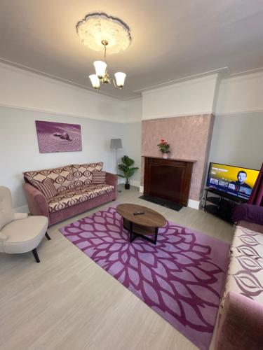 uma sala de estar com um sofá e uma mesa em Newly renovated, spacious East London home em Seven Kings