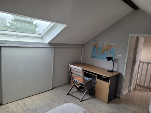 Zimmer mit einem Schreibtisch mit einer Lampe und einem Fenster in der Unterkunft Chez Fabrice in Nantes