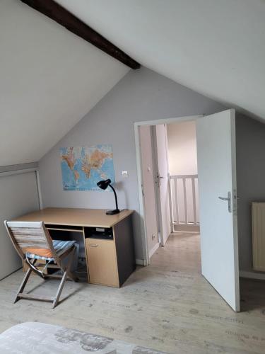 Cette chambre mansardée comprend un bureau et une chaise. dans l'établissement Chez Fabrice, à Nantes