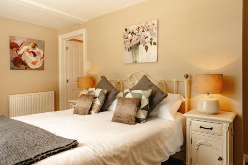 um quarto com uma cama com lençóis brancos e almofadas em Wheatacre White Lion em Burgh Saint Peter