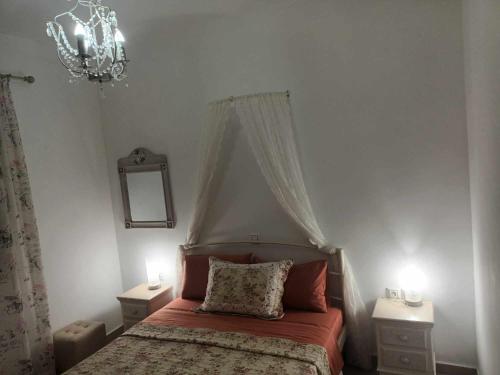 a bedroom with a bed and a chandelier at Lina's House Sivota in Sivota
