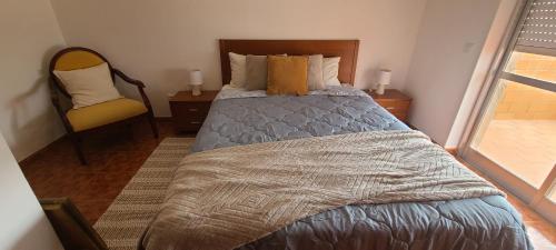 um quarto com uma cama, uma cadeira e uma janela em Chez Marlene em Lagos