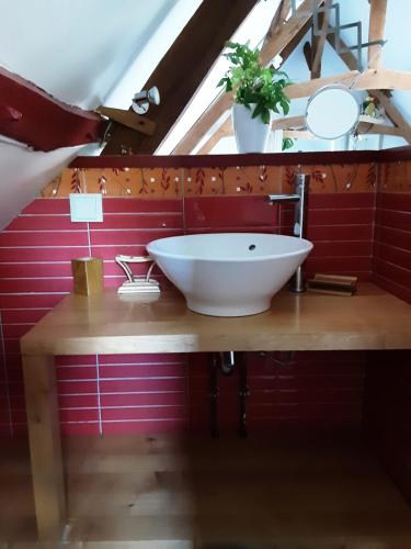 a bathroom with a white sink on a wooden counter at La grange de Fermont in Capelle-Fermont