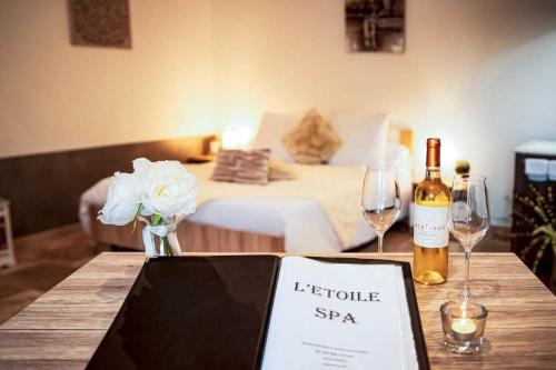 a table with a bottle of wine and two glasses at Gites spa de charme L ETOILE SPA in Beynac-et-Cazenac