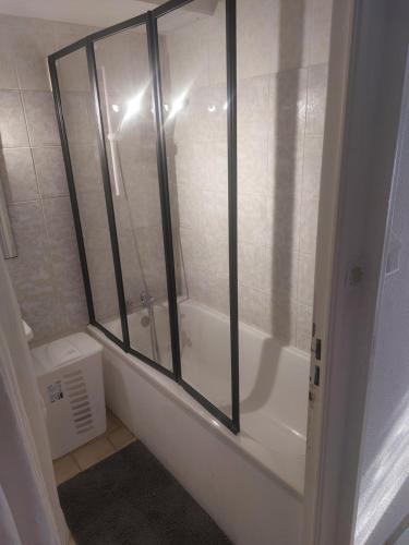 uma casa de banho com uma banheira e uma cabina de duche em vidro. em T2 Montpellier plein sud clim wifi terrasse de 16m2 em Montpellier