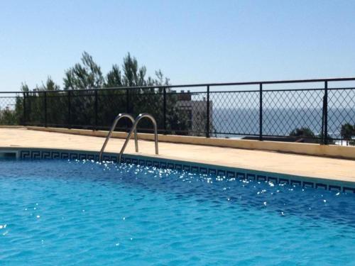 a swimming pool with a metal fence and a swimming pooliterator at Quinta das Rosas - Beach and Mountain apartment in Buarcos