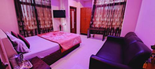a bedroom with a bed and a couch and a chair at Shillong Guest House in Shillong