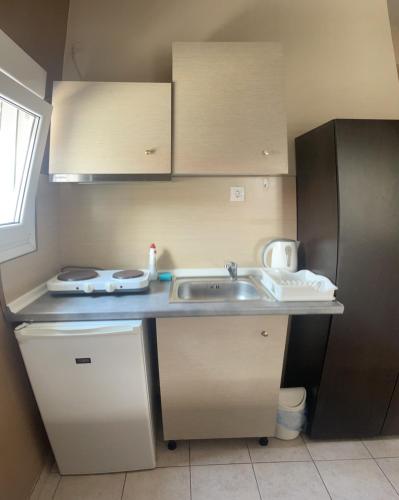 a small kitchen with a sink and a refrigerator at House Filippos in Sarti