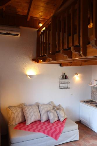 Auberge Kalopetri في Kamiros: غرفة معيشة مع أريكة وبطانية حمراء
