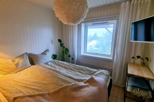 a bedroom with a bed and a window and a pom at Private Mountain Apartment in Narvik