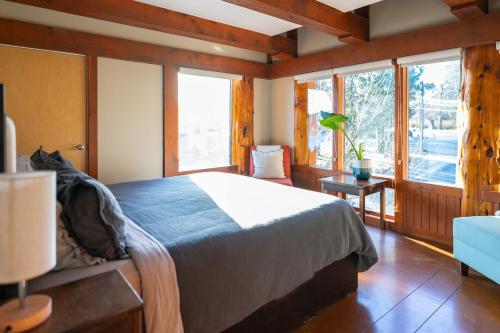 een slaapkamer met een bed in een kamer met ramen bij Waterfront Condo in Ucluelet in Ucluelet