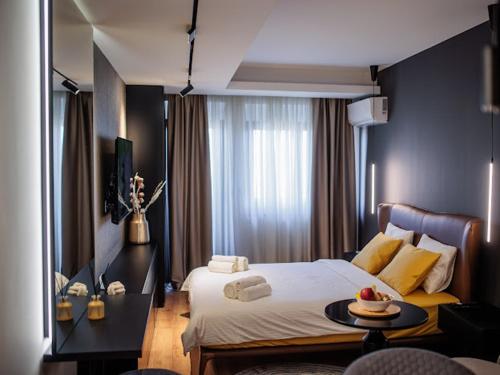 ein Hotelzimmer mit einem Bett und einem Tisch mit Essen darauf in der Unterkunft Butterfly in Kragujevac