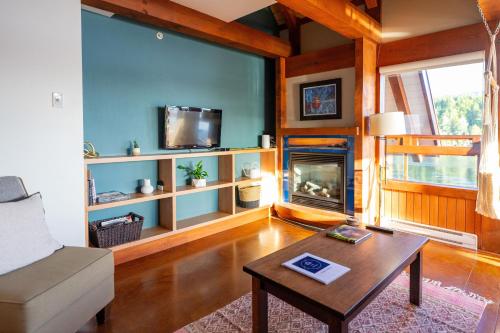 a living room with a couch and a fireplace at Waterfront Condo in Ucluelet in Ucluelet