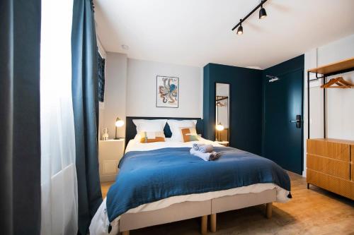 een slaapkamer met blauwe muren en een bed met een teddybeer erop bij Studio détente en hypercentre, Cathédrale in Orléans