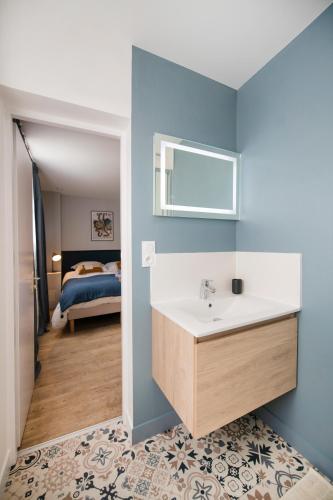 een badkamer met een wastafel en een slaapkamer bij Studio détente en hypercentre, Cathédrale in Orléans