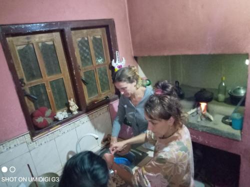 two women washing dishes in a sink in a kitchen at Milan Home Stay in Ella