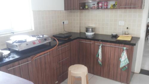 a kitchen with wooden cabinets and a counter top at WeKare Archid Royal Service Apartment in Bhubaneshwar