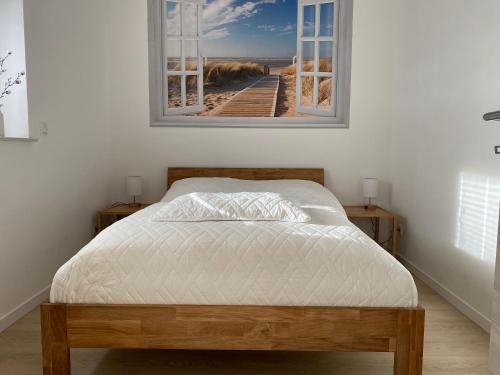 een bed in een slaapkamer met een foto van een strand bij Neu! Modern am Bowlingcenter in Werlte
