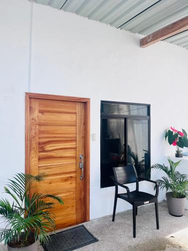 a wooden door and a chair next to a patio at GALAPAGOS HOME in Puerto Ayora